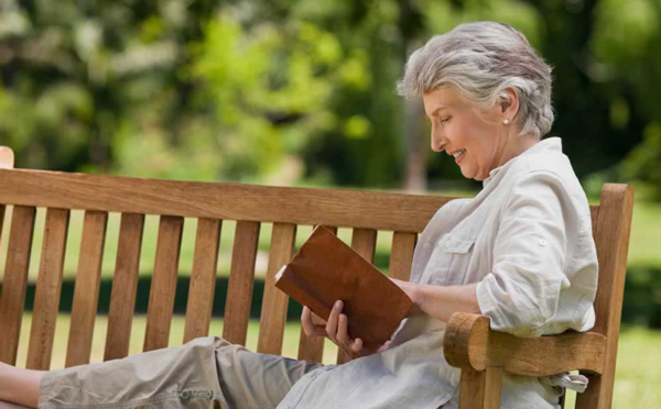 Woman reading a book on a bench
